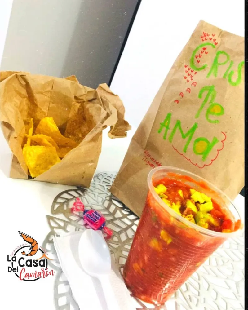 Bolsa de choclitos junto a un vaso de ceviche