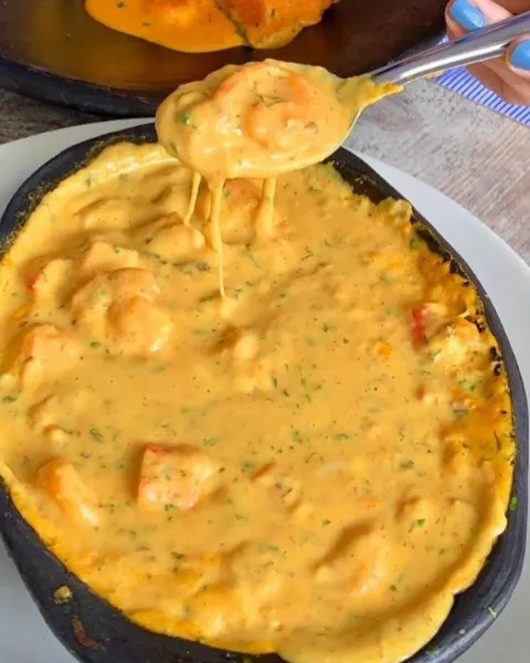 Cazuela de mariscos gratinada con el queso estirándose