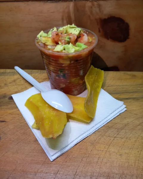 Vaso de ceviche sobre mesa de madera