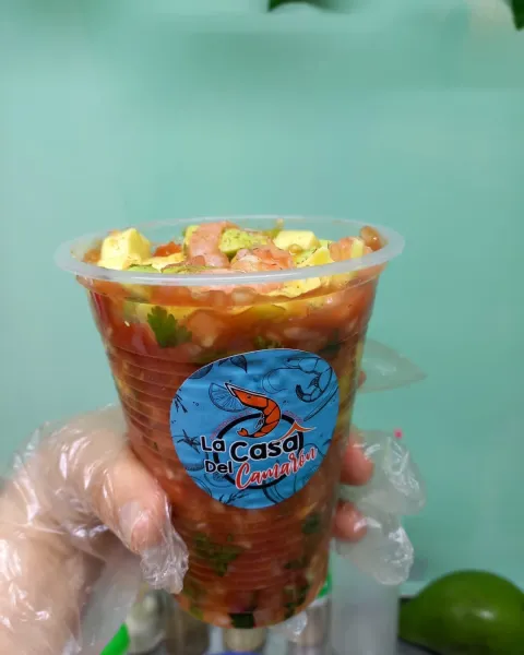 Una mano sostiene un vaso de ceviche mexicano