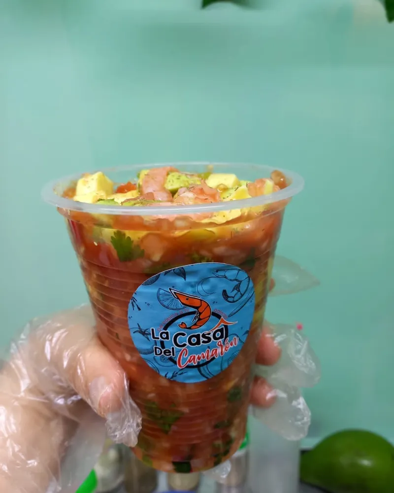 Una mano sostiene un vaso de ceviche mexicano